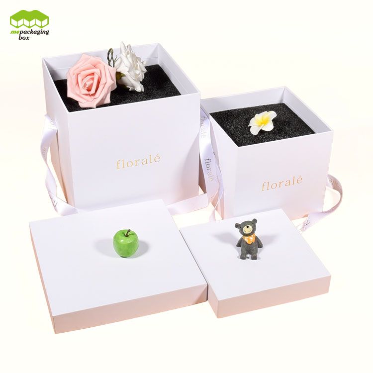 Caja de regalo de papel con flores y asas de cinta simples