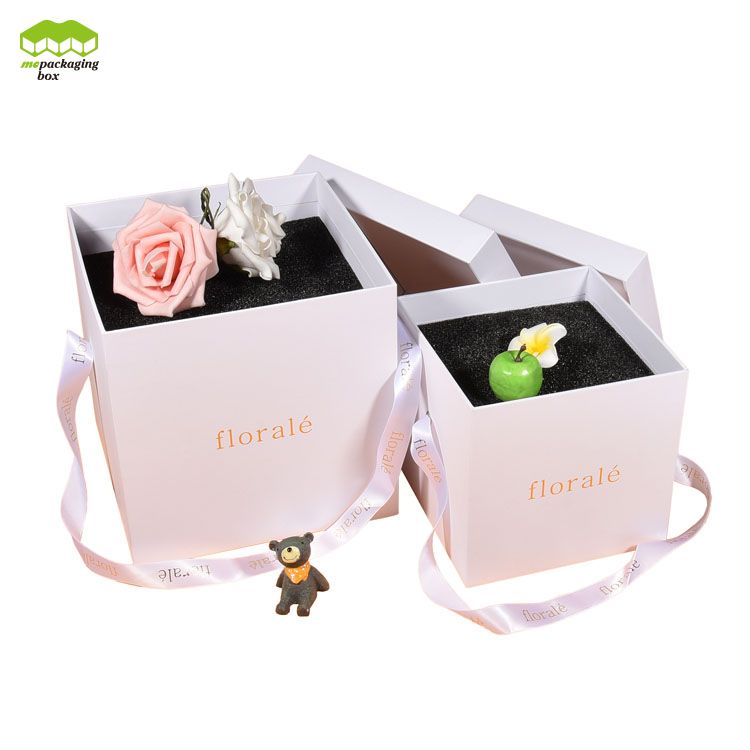Caja de regalo de papel con flores y asas de cinta simples