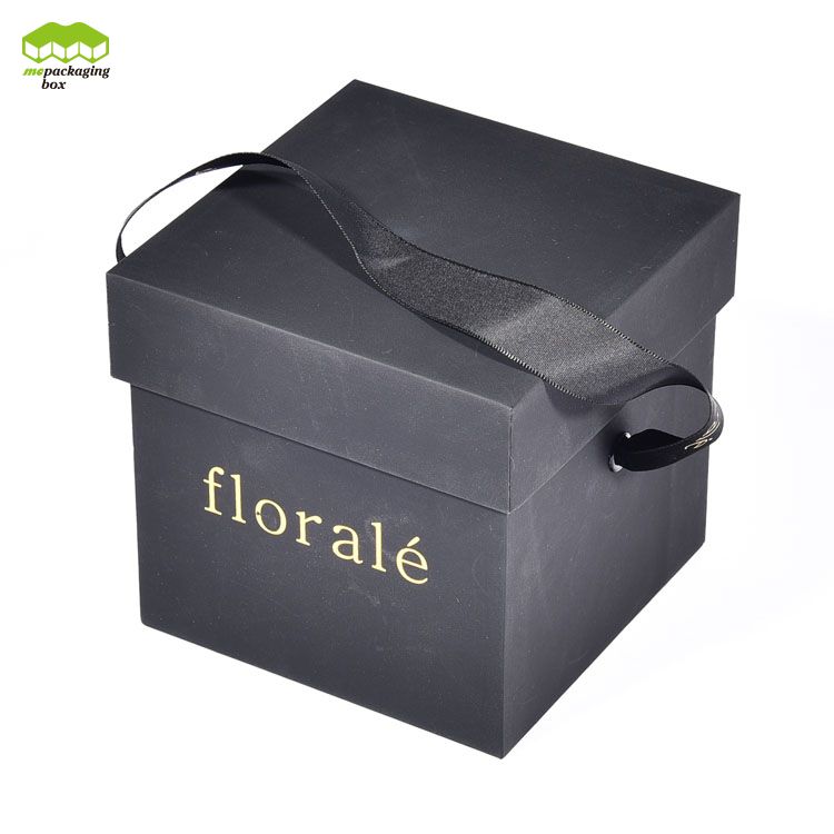 Caja de regalo de papel con flores y asas de cinta simples